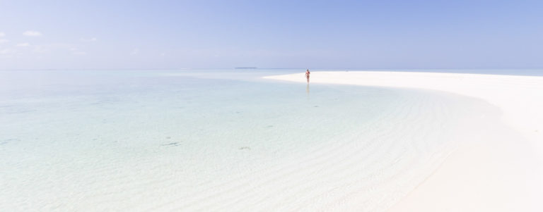 Dolga peščena plaža sredi morja, Maldivi.